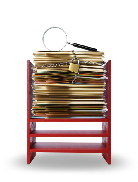 一个放大镜，放在一个堆放在一起的棕色文件夹上，用链条系在一个红色的木制架子上，上面是白色的背景。图片下载