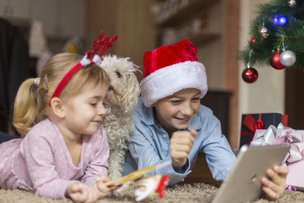 孩子们在玩电子平板电脑，他们的狗抱着他们图片下载