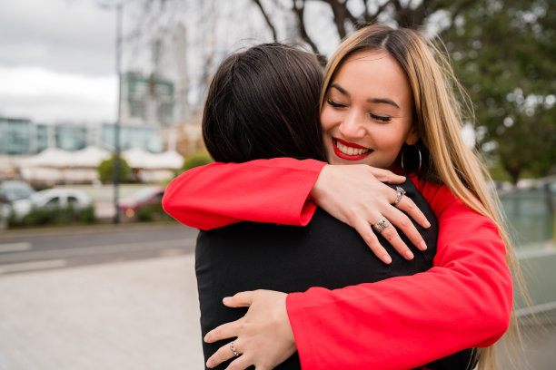 两个年轻的朋友拥抱在一起。图片下载