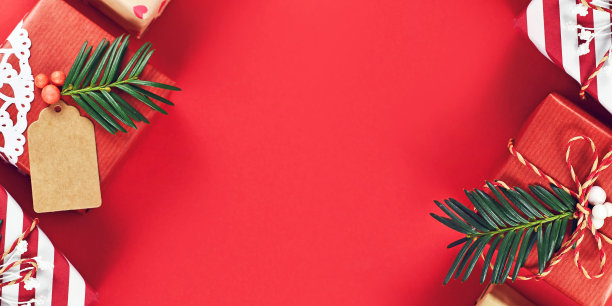 圣诞节横幅与美丽的红色，白色和天然棕色装饰礼盒丝带和杉树枝在红色的背景图片下载