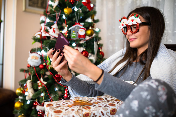 一个漂亮的年轻女人戴着有趣的圣诞眼镜在自拍图片下载