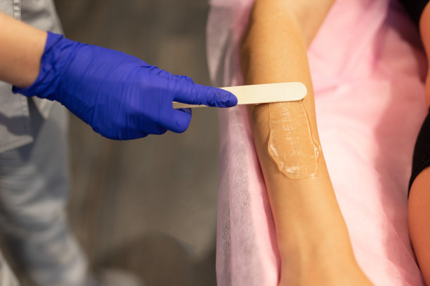 美容师将激光脱毛凝胶应用于患者的手臂图片下载