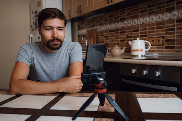 年轻人在家庭办公室里通过智能手机进行视频通话。图片下载