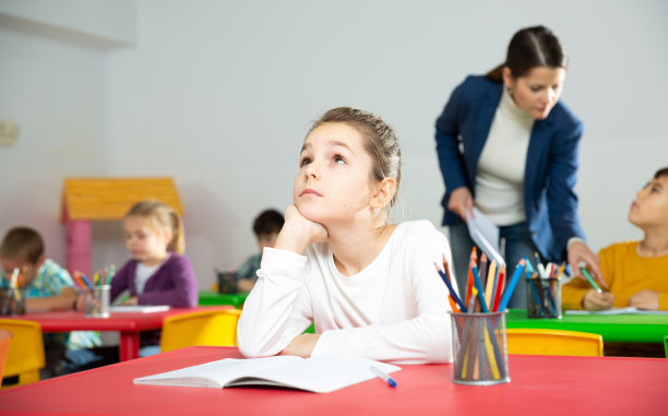 小学疲惫的女学生坐在教室里的肖像图片下载
