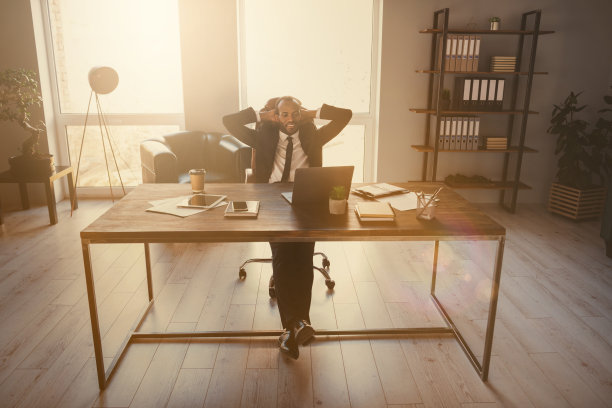 全身照片正面的非洲裔美国人代表企业家伸开双手坐桌子观看训练目标进展视频笔记本穿西装夹克燕尾服在工作场所工作站图片下载