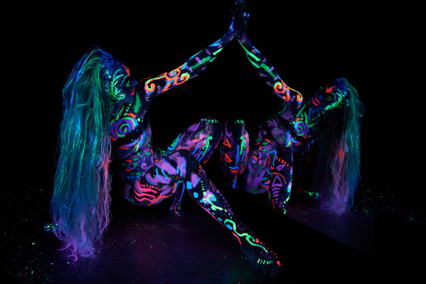 艺术女人的身体艺术在紫外线下跳舞的身体。鲜艳的抽象画上霓虹色的女子身体。彩色的头发和脸图片下载