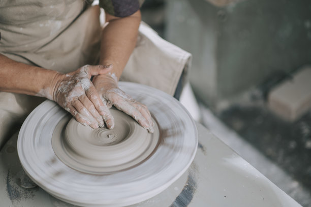 亚洲华人高级泥塑艺术家在他的工作室与纺织陶轮工作图片下载