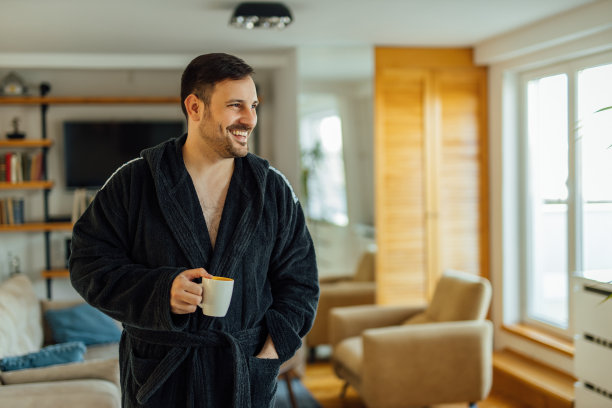 一个穿着浴袍的英俊男子在家里放松的肖像。图片下载
