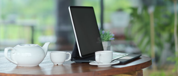 工作空间模拟空白屏幕平板电脑键盘和茶壶设置在桌子上图片下载