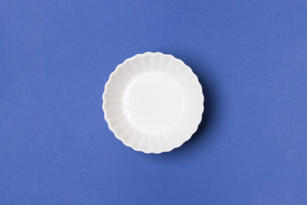 空白的白色盘子在蓝色的纸背景图片下载