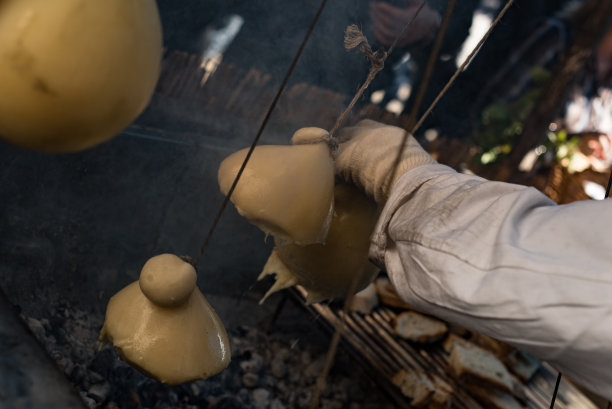意大利街头食品。在坎帕尼亚小镇蒙特拉的集市上，Caciocavallo在烤架上融化了。Caciocavallo“挂”。栗的节日。特写照片。图片下载