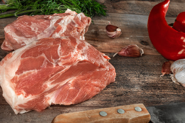 一块生肉准备与绿色和香料。乡村木制背景。图片下载