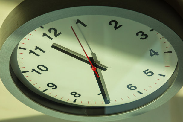 靠近一个挂钟，上面有一个红色的秒针。图片下载