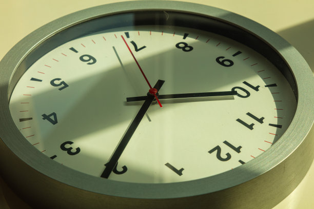 靠近一个挂钟，上面有一个红色的秒针。图片下载