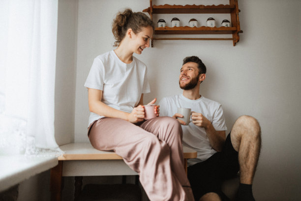 年轻愉快的夫妇在厨房里喝茶或咖啡图片下载