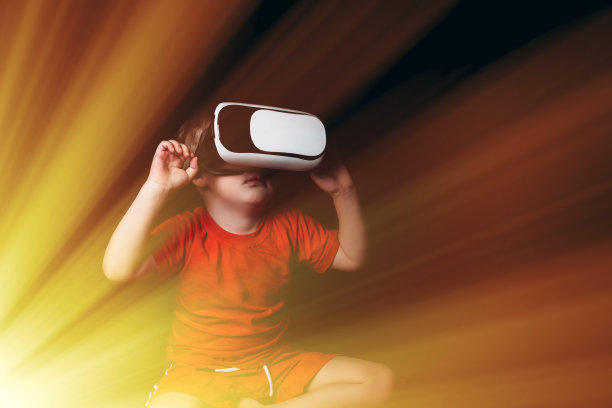 小男孩体验虚拟现实在黑色背景与光的发光效果图片下载