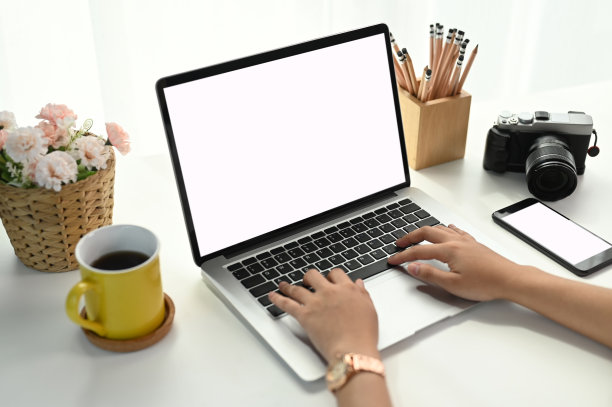 女性在笔记本电脑键盘上打字的剪影包括她办公室白色桌子上的剪影路径。图片下载