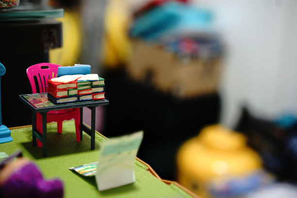 一堆书放在桌上的玩具上，背景模糊图片下载