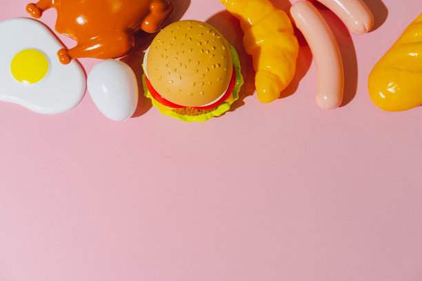 汉堡、鸡肉或火鸡、香肠、煎蛋和羊角面包等派对餐配料。创意塑料平铺概念。极简主义图片下载