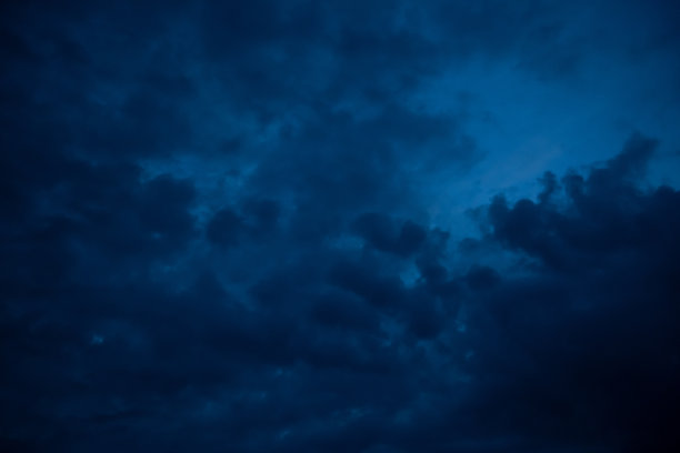 黎明时分，乌云密布的天空是深蓝色的图片下载