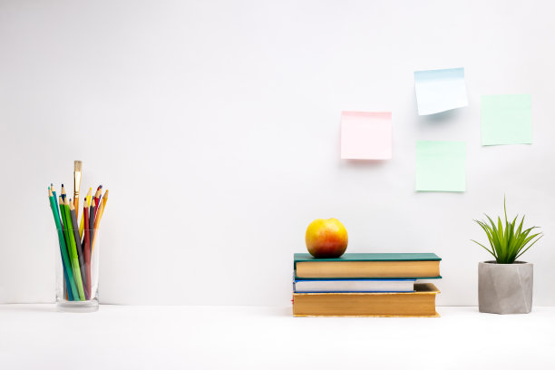 白色的书桌背景。学习用的书，桌上放着文具。离线工作。侧视图图片下载