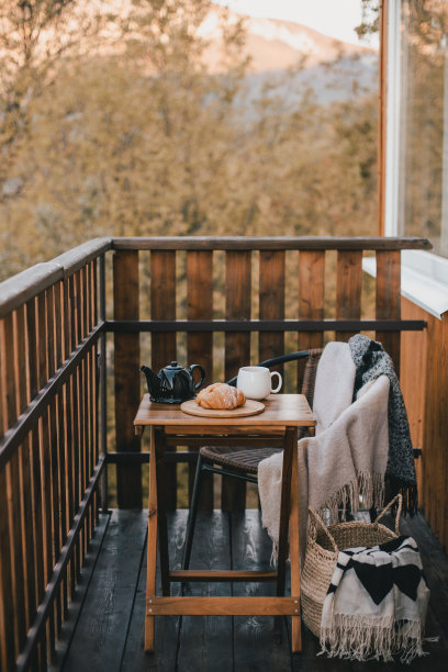 秋天的早餐，热茶和羊角面包，在一个木制乡村别墅舒适的阳台上。秋天的气氛。慢生活的概念。图片下载