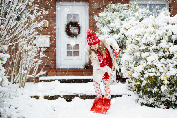 孩子在铲冬天的雪。孩子们清晰的车道。图片下载