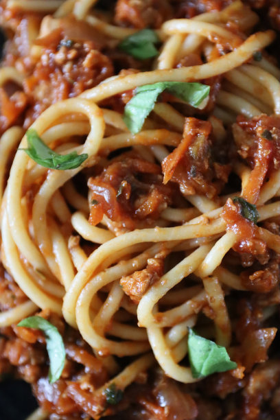 全框图片自制的肉酱部分与瘦牛肉碎，丰富的番茄酱，洋葱，大蒜和罗勒叶装饰混合意大利面意大利面，高的观点图片下载