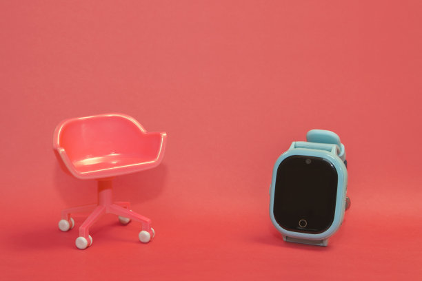 空椅子的概念。粉红色的凳子与蓝色的孩子智能手表在粉红色干净的背景。以极简风格拍照。图片下载