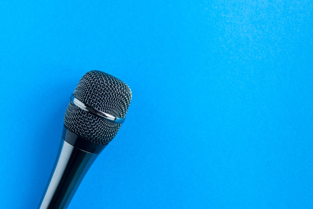 麦克风在一个彩色的蓝色背景接近。唱歌，写音乐，网上卡拉ok，创意，声乐概念，符号。歌唱课图片下载