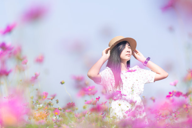 亚洲女人与白色的衣服放松在花园里的玛格丽特阿斯特花田图片下载