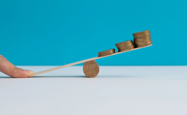 女人用手指在跷跷板上平衡硬币图片下载