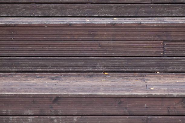 以棕色和灰色为背景的木条紧密地相互碰撞，形成装饰性的舞台或秋季构图。环保建筑和装饰材料。图片下载