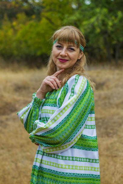 一个年轻的金发女人的肖像穿着红色的民间绿色服装。图片下载