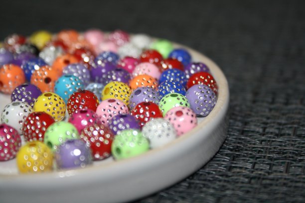 玻璃透明碟上的彩色装饰珠图片下载