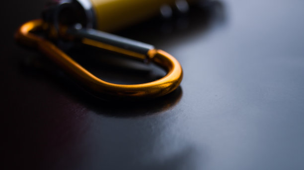 暗色背景下具有多种模式的激光笔的底部。激光上的金属卡宾枪。点东西。孩子们的玩具。黄色的小金属手电筒。文本。图片下载