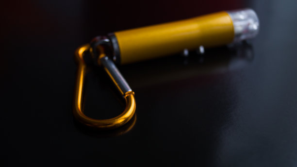 在黑暗背景下具有多种模式的激光指针。激光上的金属卡宾枪。点东西。孩子们的玩具。黄色的小金属手电筒。文本。专注于卡宾枪。图片下载
