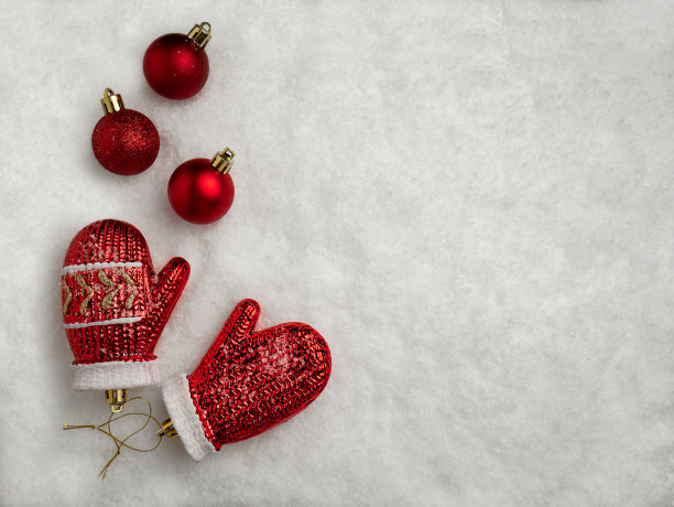 节日装饰。玻璃圣诞树玩具红色手套和球在雪地里。圣诞概念与空间的副本图片下载