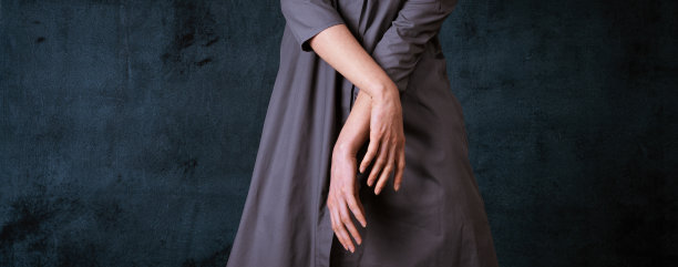 纤瘦的女人没有一张美丽的脸，双手放在黑暗的背景上，孤独的概念图片下载