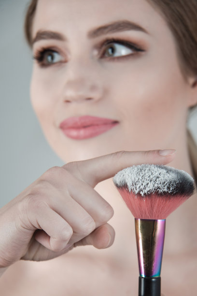 漂亮的年轻女子，手里拿着粉刷图片下载