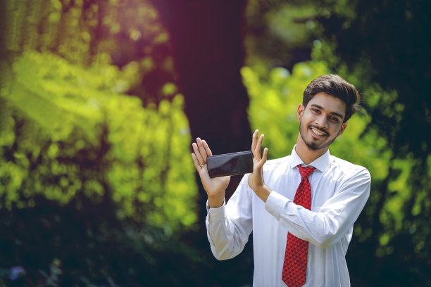 拷贝他智能手机上的空间。自信的印度年轻人展示他的智能手机图片下载