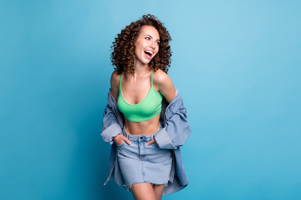 漂亮可爱的照片精力充沛的女士模特看起来空的空间口袋看到折扣销售购物衣服广告横幅穿绿色的上衣牛仔裤夹克裙子孤立的淡蓝色背景图片下载