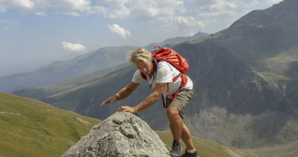 登山者爬上山脊图片下载
