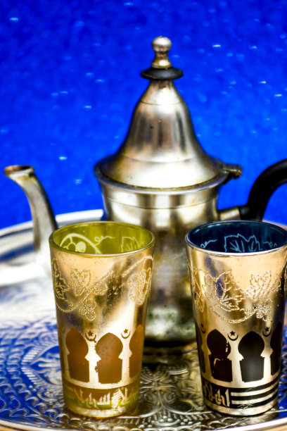 一组茶壶和东方茶在托盘上的蓝色背景闪烁图片下载