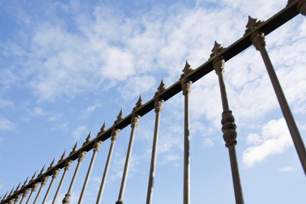 复古风格的铸铁围栏，清澈的天空云景背景。图片下载