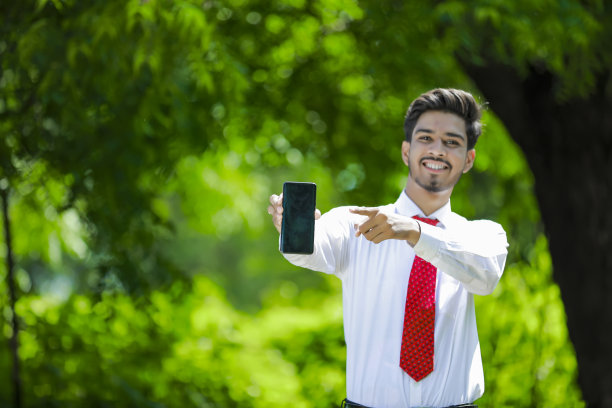 拷贝他智能手机上的空间。自信的印度年轻人展示他的智能手机图片下载