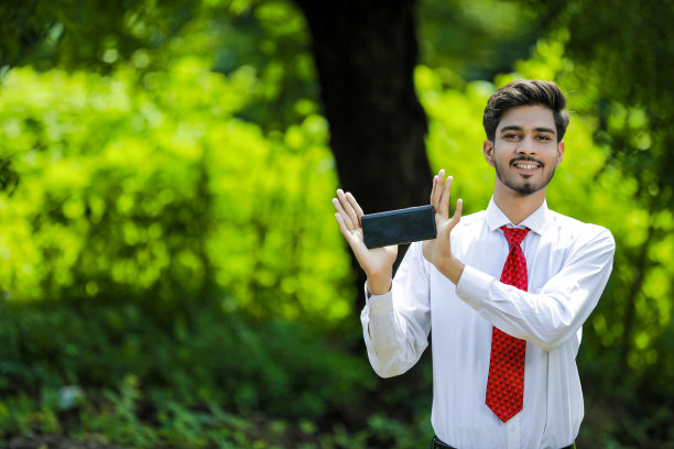 拷贝他智能手机上的空间。自信的印度年轻人展示他的智能手机图片下载
