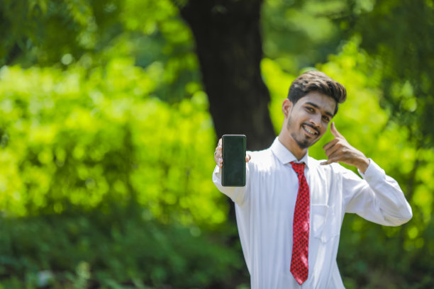 拷贝他智能手机上的空间。自信的印度年轻人展示他的智能手机图片下载