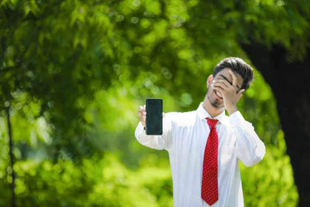 拷贝他智能手机上的空间。自信的印度年轻人展示他的智能手机图片下载