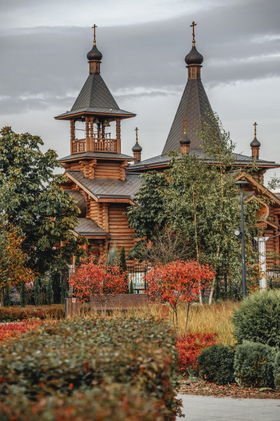 木制的东正教教堂与秋天的树叶在前景图片下载
